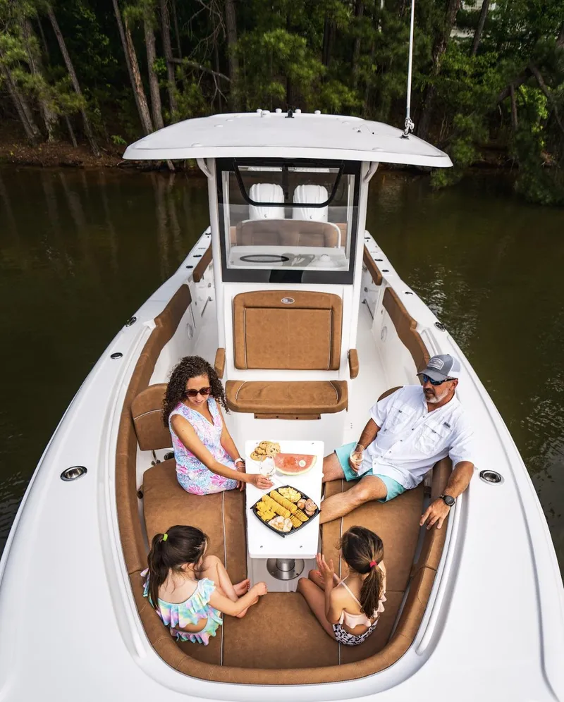 Slide: The Image of Family enjoying a meal on a 2025 Sea Hunt Ultra 305 SE boat. - 25