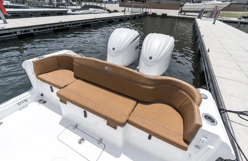 Slide: The Image of 2025 Sea Hunt Ultra 305 SE boat with tan seating and dual engines at dock. - 8
