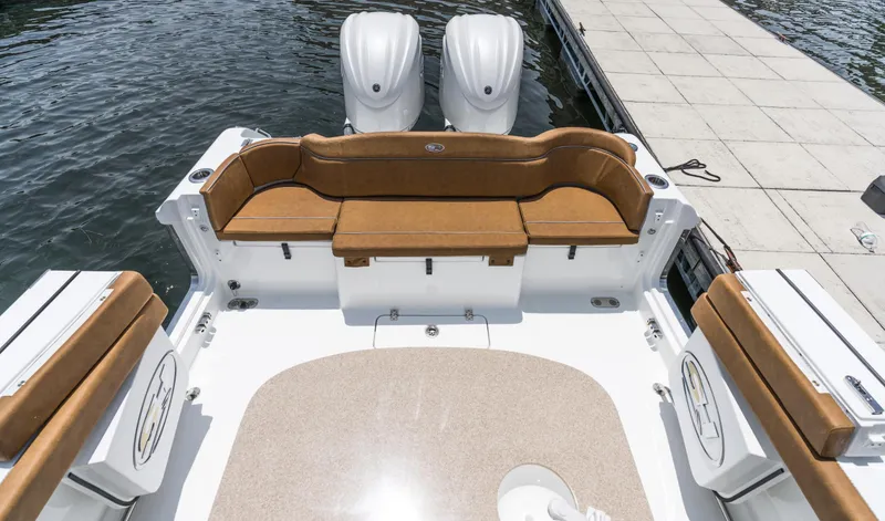 Slide: The Image of 2025 Sea Hunt Ultra 305 SE boat with twin engines and spacious seating at dock. - 9