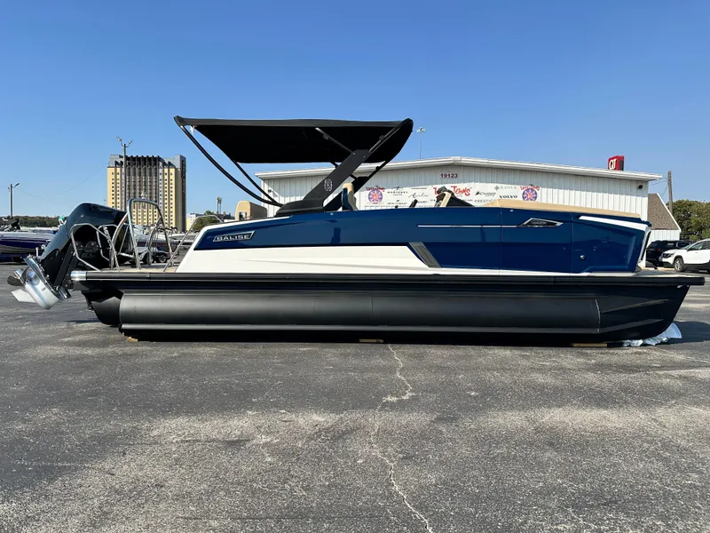 Slide: The Image of 2025 Balise HORIZON 24L boat with canopy, parked on asphalt, side view. - 2