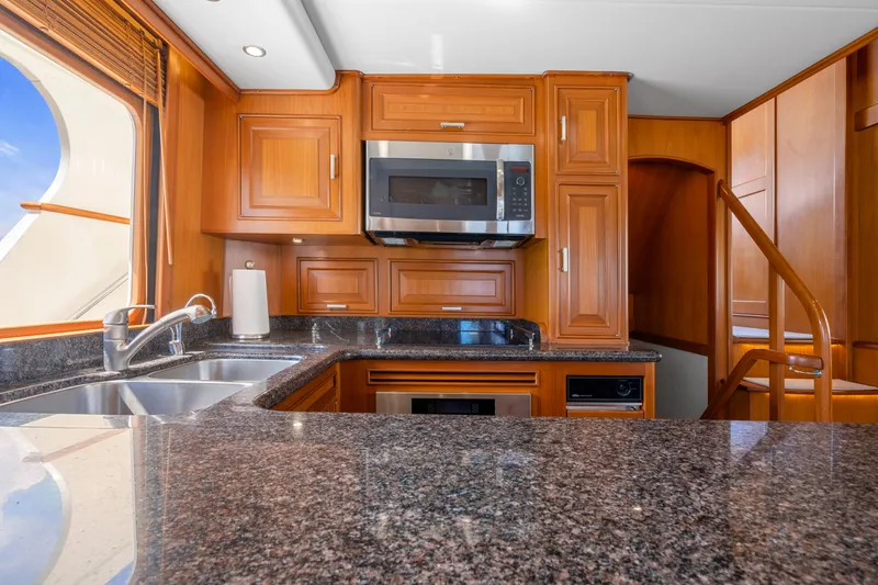 Slide: The Image of Luxurious kitchen interior of 2007 Fleming 65 yacht with wooden cabinetry and granite countertops. - 12