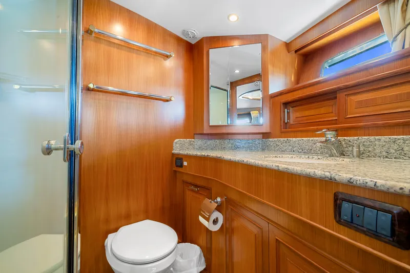 Slide: The Image of Luxurious bathroom in a 2007 Fleming 65 yacht with wood accents and granite countertop. - 20