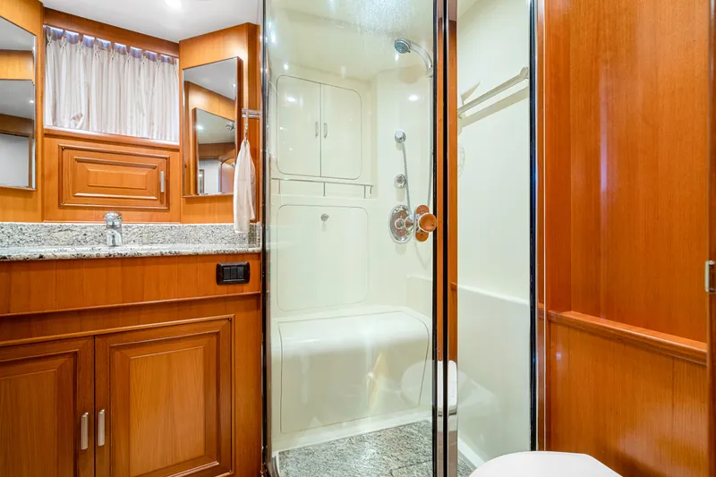 Slide: The Image of Luxurious bathroom in 2007 Fleming 65 yacht with wooden cabinetry and glass shower. - 25