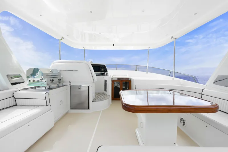 Slide: The Image of Luxurious 2007 Fleming 65 yacht interior with seating, table, and grill under a clear blue sky. - 37