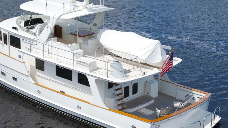 Slide: The Image of Luxury 2007 Fleming 65 yacht cruising on calm waters, featuring spacious deck and elegant design. - 44