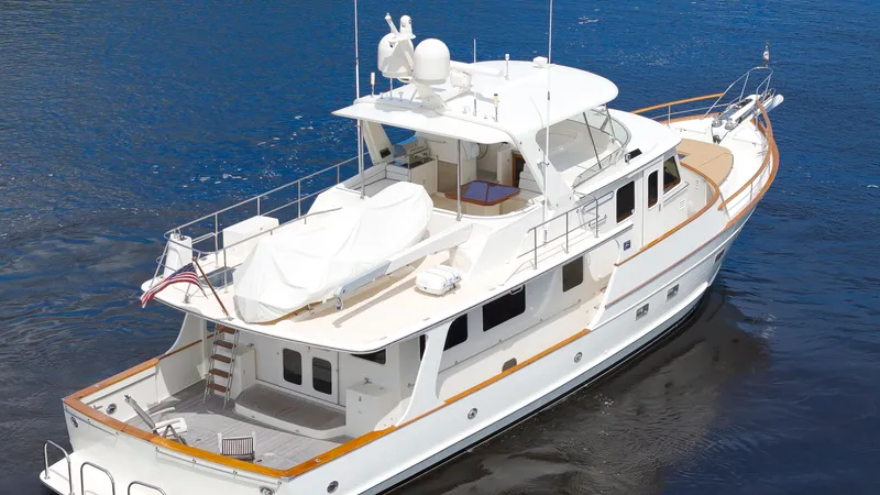 Slide: The Image of Luxury 2007 Fleming 65 yacht on calm blue water, showcasing elegant design and spacious deck. - 46