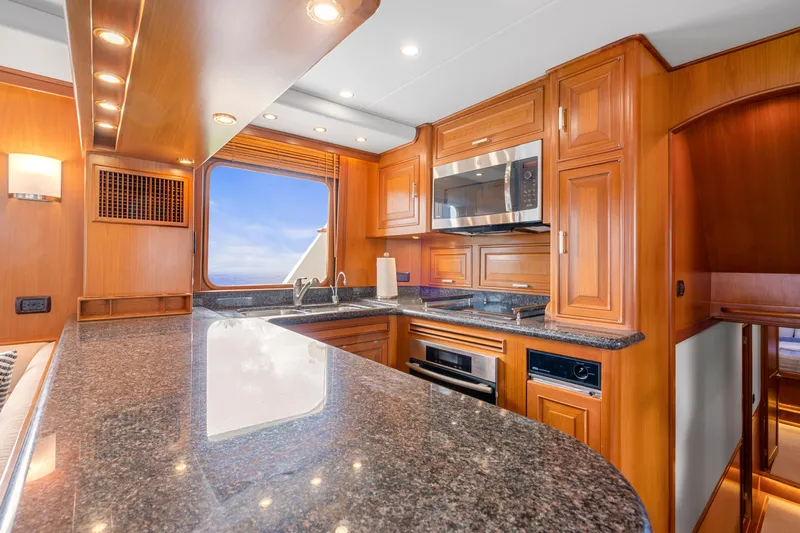 Slide: The Image of Luxurious kitchen interior of a 2007 Fleming 65 yacht with wooden cabinetry and granite countertops. - 5