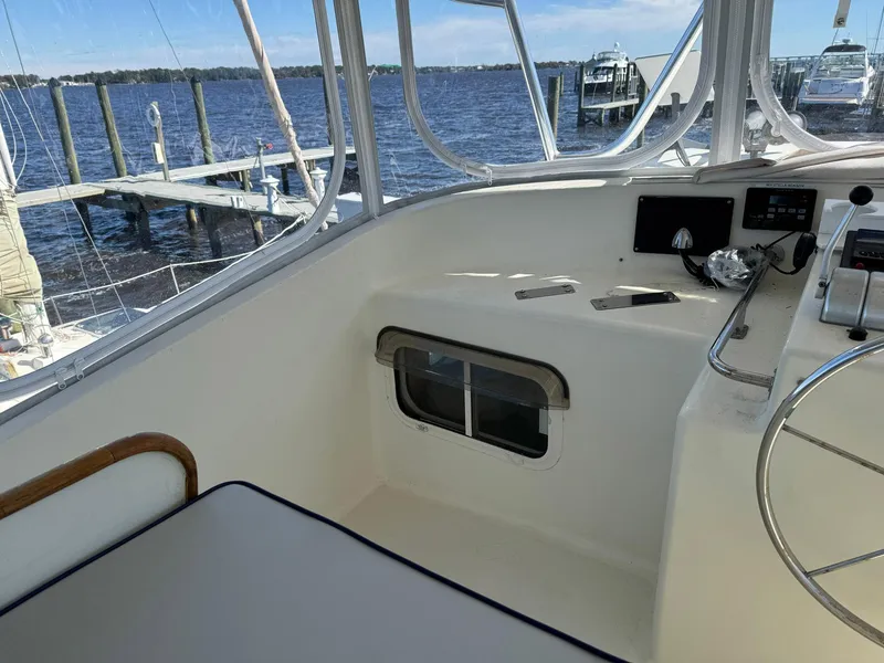 Slide: The Image of Seaton Ross 56 Trawler 1989 helm with river view and docked boats. - 17