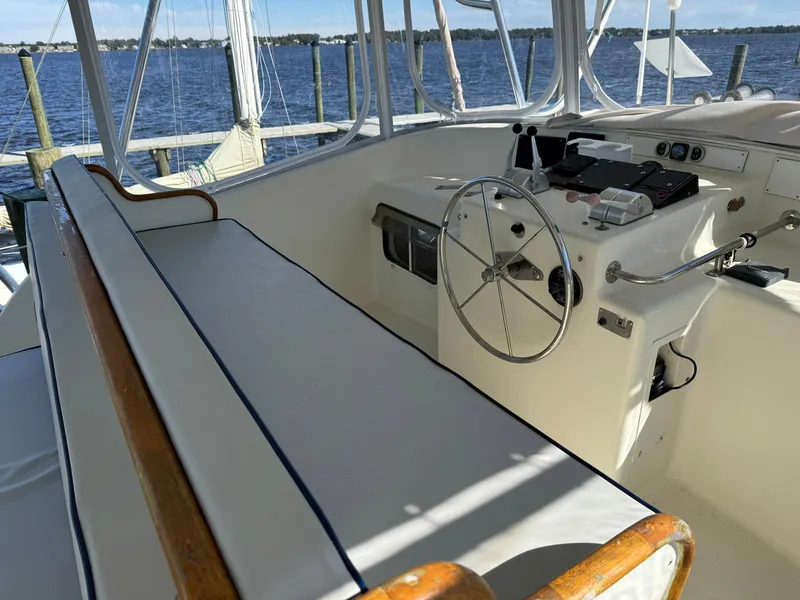 Slide: The Image of Seaton Ross 56 Trawler 1989 helm with steering wheel and seating, docked by the water. - 20