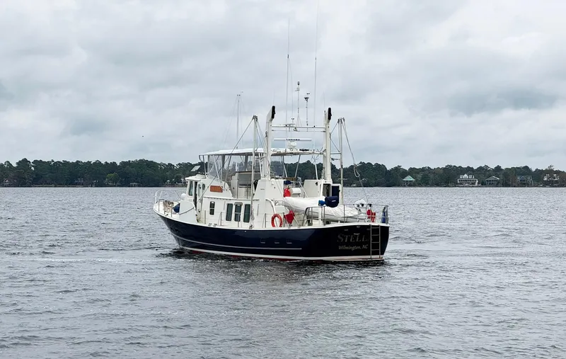 Slide: The Image of 1989 Seaton Ross 56 Trawler cruising on a calm lake under cloudy skies. - 33