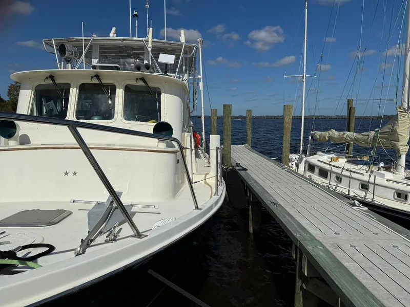 Slide: The Image of 1989 Seaton Ross 56 Trawler docked beside a wooden pier under a clear blue sky. - 7