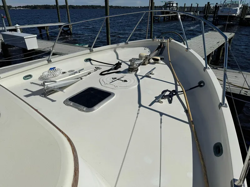 Slide: The Image of 1989 Seaton Ross 56 Trawler deck view at marina, featuring winch and railing. - 8