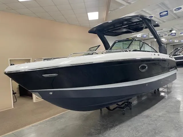 The Image of 2025 Chaparral 267 SSX boat in showroom, sleek black and white design. - 0