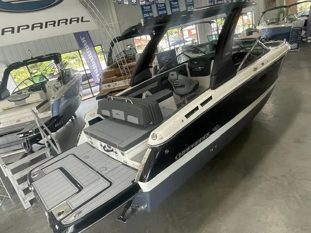 Slide: The Image of 2025 Chaparral 267 SSX boat in showroom, sleek design, luxury seating, modern features. - 15