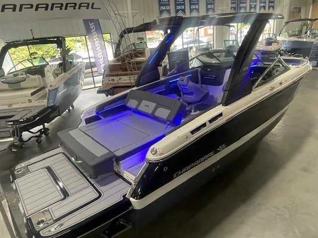 Slide: The Image of 2025 Chaparral 267 SSX boat with blue interior lighting in a showroom. - 3