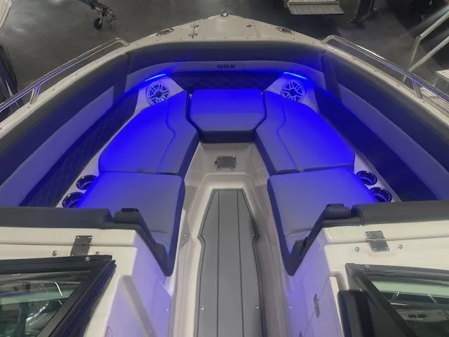 Slide: The Image of 2025 Chaparral 267 SSX boat interior with blue LED lighting and cushioned seating. - 7