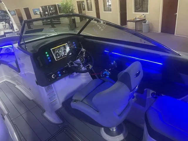 Slide: The Image of 2025 Chaparral 267 SSX boat interior with illuminated dashboard and seating. - 9