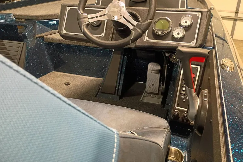Slide: The Image of 2025 Ranger Z521 boat cockpit with steering wheel, gauges, and throttle controls. - 9