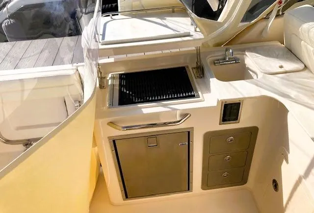 Slide: The Image of 2021 Grady-White Freedom 325 boat interior with grill, sink, and storage compartments. - 13