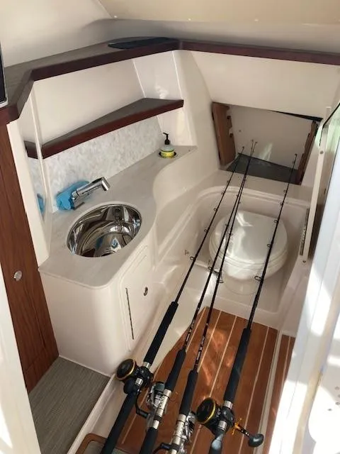 Slide: The Image of 2021 Grady-White Freedom 325 boat interior with fishing rods and compact sink area. - 18