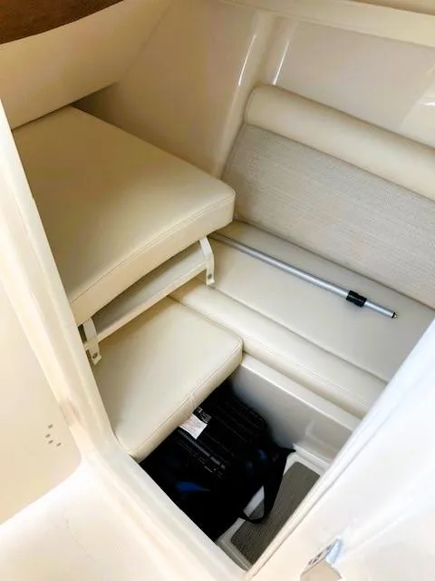 Slide: The Image of 2021 Grady-White Freedom 325 interior cabin with beige seating and storage area. - 19