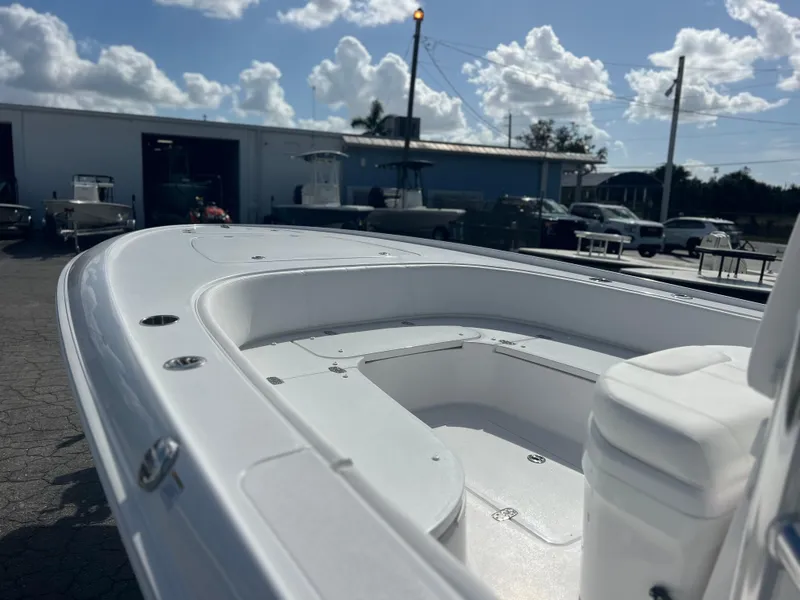 Slide: The Image of 2025 Contender 26 Bay boat, white deck, outdoor marina setting, cloudy sky. - 10