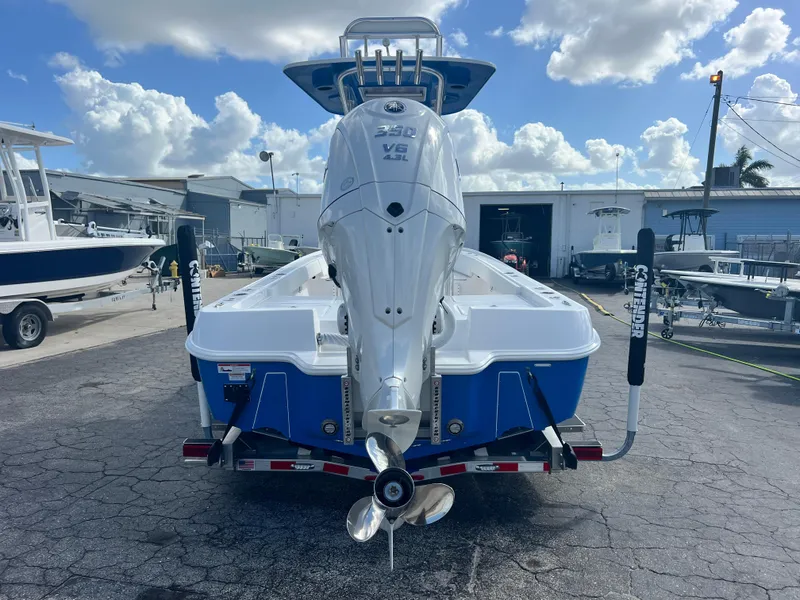 Slide: The Image of 2025 Contender 26 Bay boat with powerful outboard motor, parked on a trailer. - 11