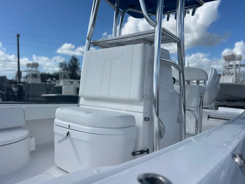 Slide: The Image of 2025 Contender 26 Bay boat interior with seating and console, under a blue sky. - 3