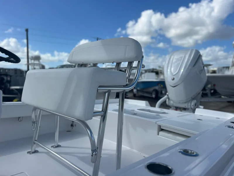 Slide: The Image of 2025 Contender 26 Bay boat interior with seating and motor, under a blue sky. - 4