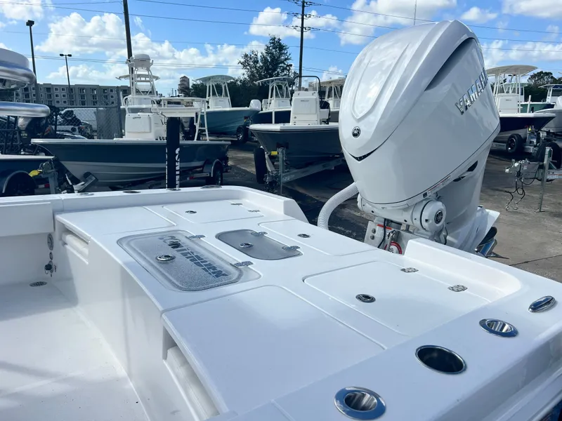 Slide: The Image of 2025 Contender 26 Bay boat with powerful outboard motor, docked in a marina. - 6