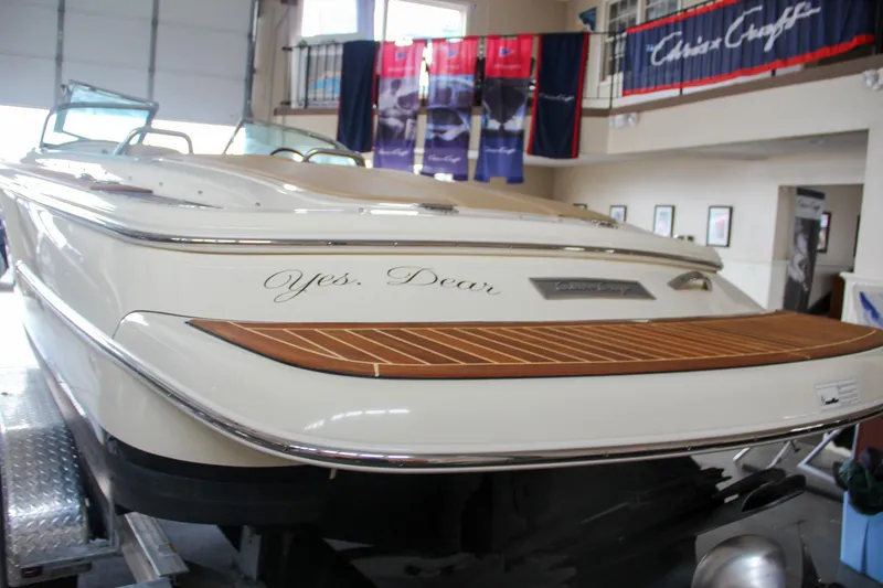 Slide: The Image of 2014 Chris-Craft Launch 22 boat in showroom, featuring elegant wood detailing. - 13