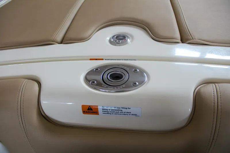 Slide: The Image of 2014 Chris-Craft Launch 22 boat interior detail with beige upholstery and warning label. - 30