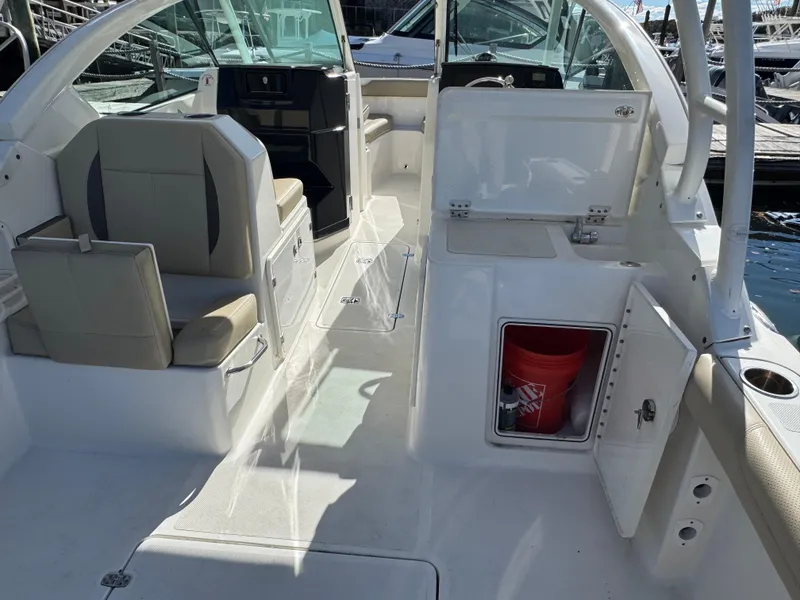 Slide: The Image of 2020 Pursuit DC 266 Dual Console boat interior with seating and storage compartments. - 2