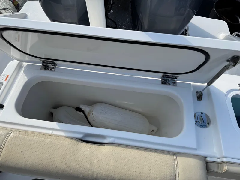 Slide: The Image of Open storage compartment on 2020 Pursuit DC 266 Dual Console boat. - 20