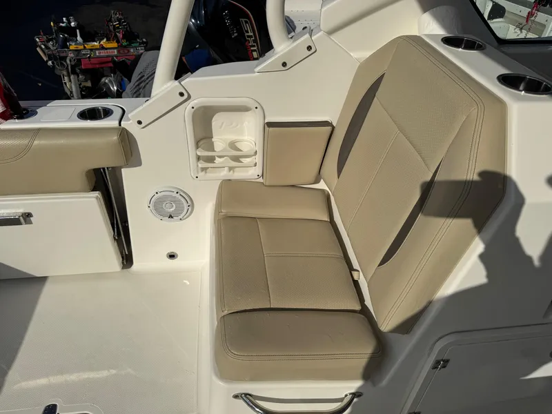 Slide: The Image of 2020 Pursuit DC 266 Dual Console boat interior with beige seating and cup holders. - 24