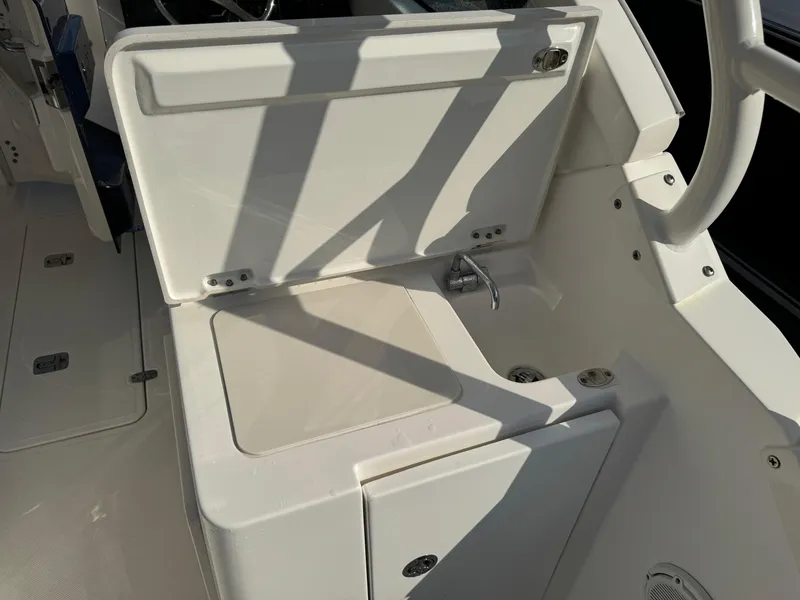 Slide: The Image of 2020 Pursuit DC 266 Dual Console boat interior with open storage compartment. - 26