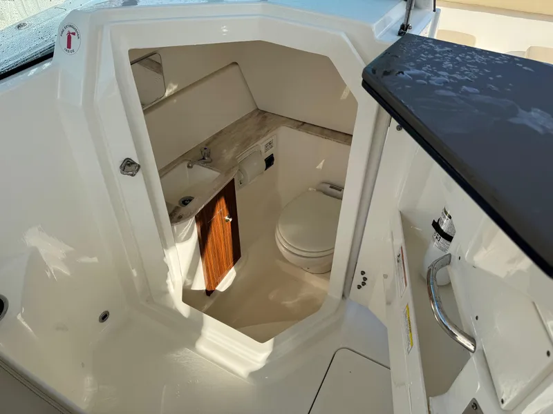 Slide: The Image of 2020 Pursuit DC 266 Dual Console boat interior with compact bathroom. - 27