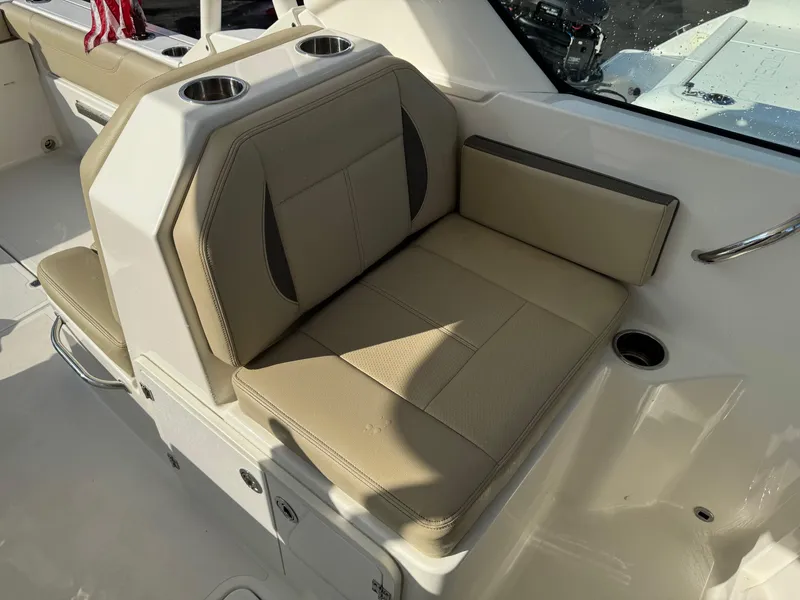 Slide: The Image of 2020 Pursuit DC 266 Dual Console boat interior with beige seating and cup holders. - 28