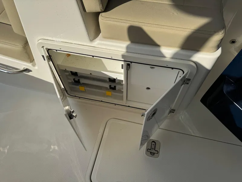 Slide: The Image of Open storage compartment on 2020 Pursuit DC 266 Dual Console boat. - 29
