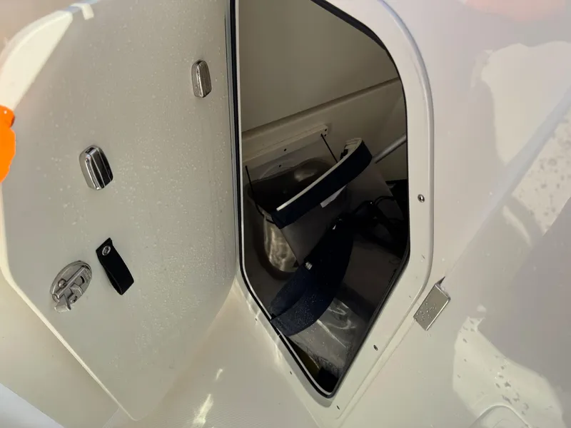 Slide: The Image of Open storage compartment on 2020 Pursuit DC 266 Dual Console boat. - 30