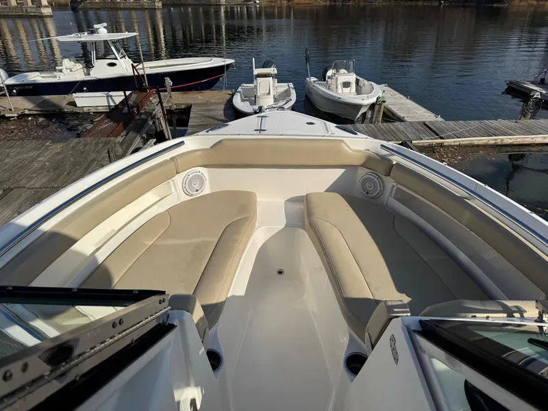 Slide: The Image of 2020 Pursuit DC 266 Dual Console boat interior with beige seating at dock. - 31