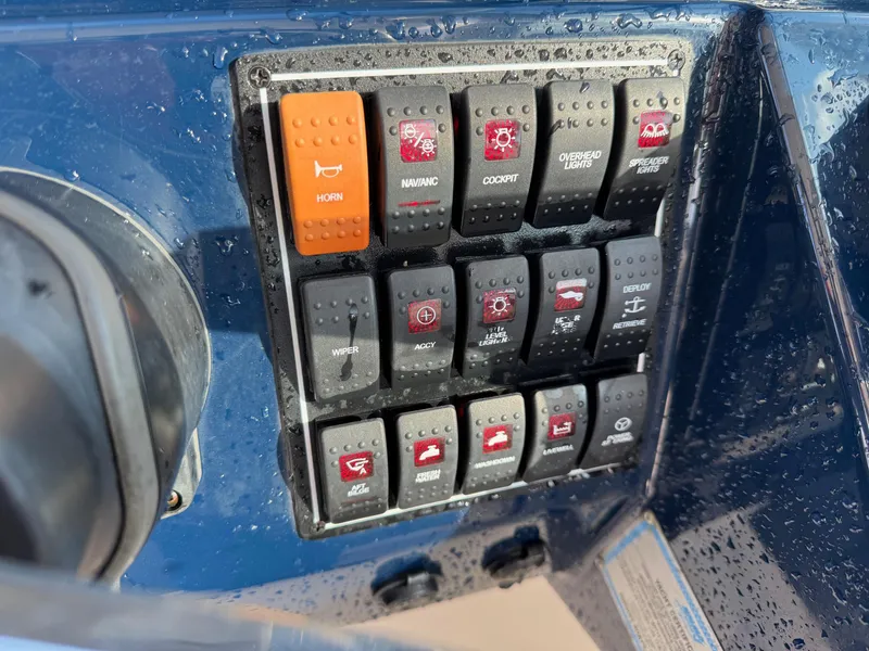 Slide: The Image of Control panel of a 2020 Pursuit DC 266 Dual Console boat with various switches. - 36