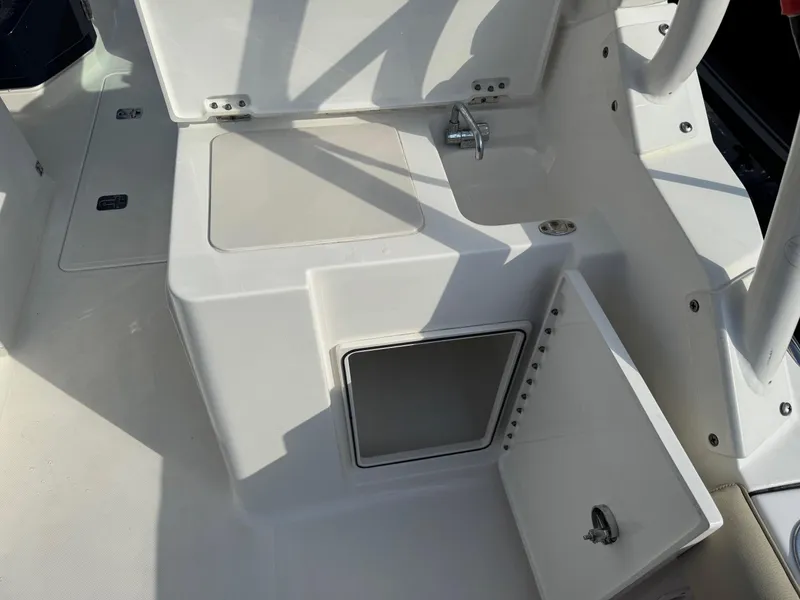 Slide: The Image of 2020 Pursuit DC 266 Dual Console boat interior with open storage compartment and sink. - 38