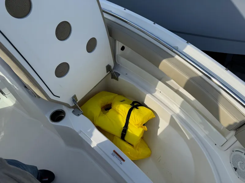 Slide: The Image of 2020 Pursuit DC 266 Dual Console boat storage with yellow life jacket. - 39