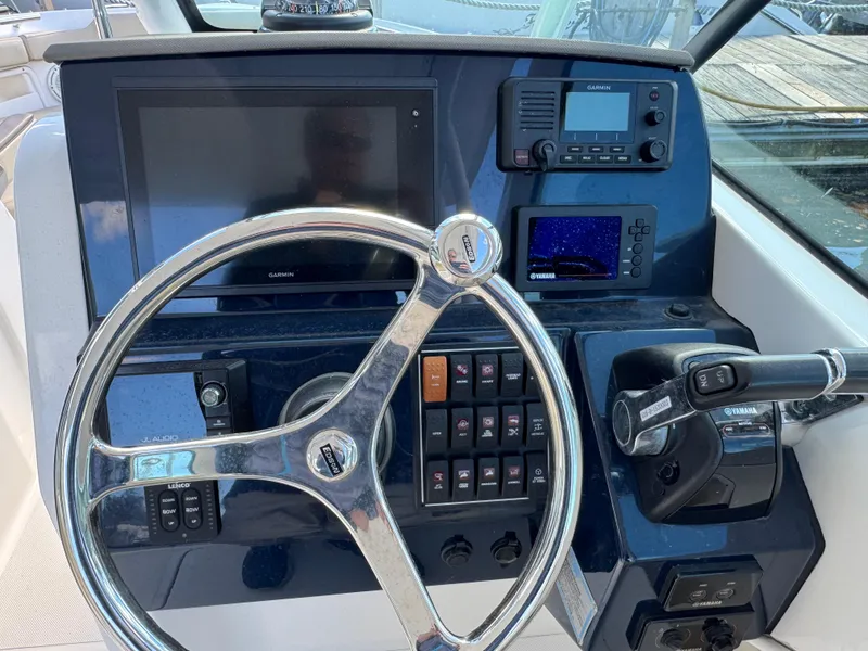 Slide: The Image of 2020 Pursuit DC 266 Dual Console boat dashboard with steering wheel and navigation controls. - 4