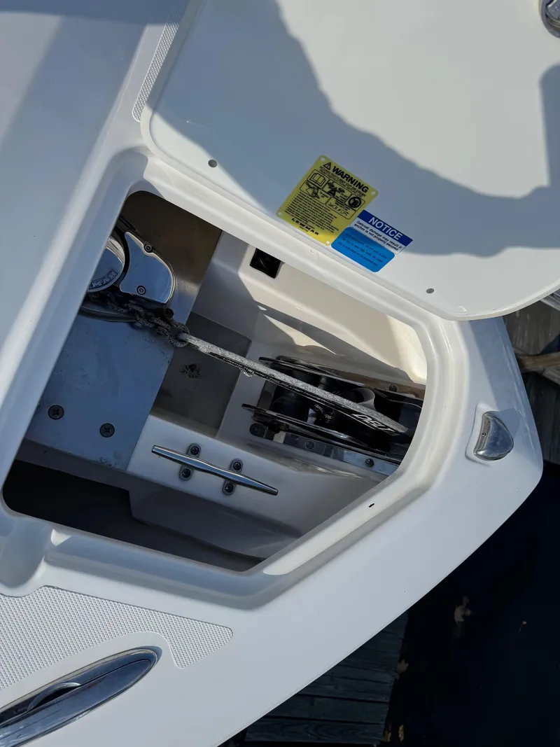 Slide: The Image of 2020 Pursuit DC 266 Dual Console anchor compartment with chain and winch. - 41