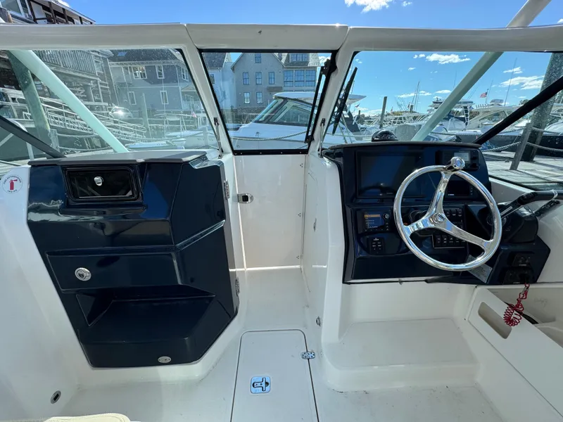 Slide: The Image of 2020 Pursuit DC 266 Dual Console boat interior with steering wheel and dashboard. - 5