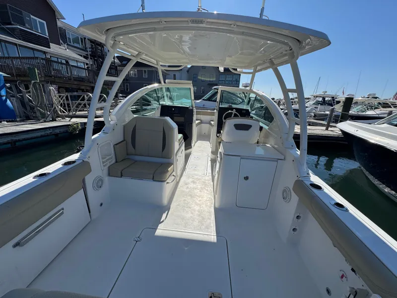 Slide: The Image of 2020 Pursuit DC 266 Dual Console boat interior at marina, featuring spacious seating and helm. - 9