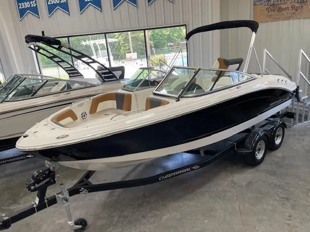The Image of 2025 Chaparral 21 SSi boat on trailer in showroom, featuring sleek design and modern amenities. - 0