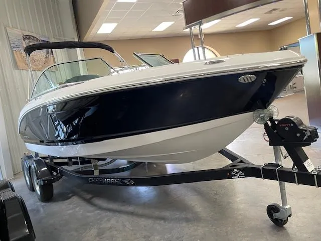 Slide: The Image of 2025 Chaparral 21 SSi boat on trailer in showroom setting. - 1